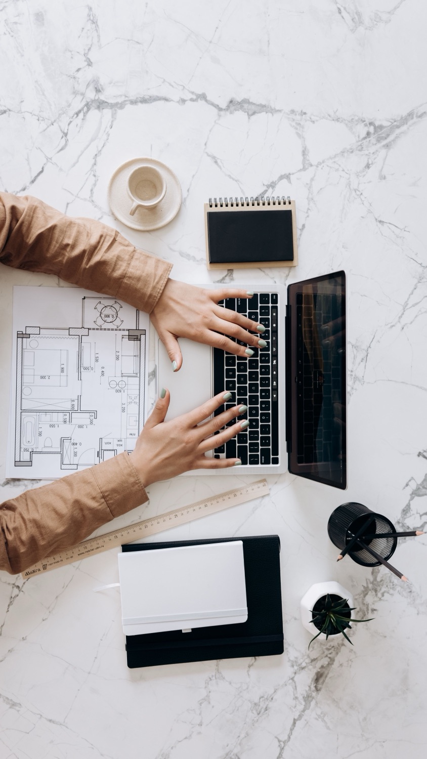 A floor plan and laptop on a desk — the material a project starts from